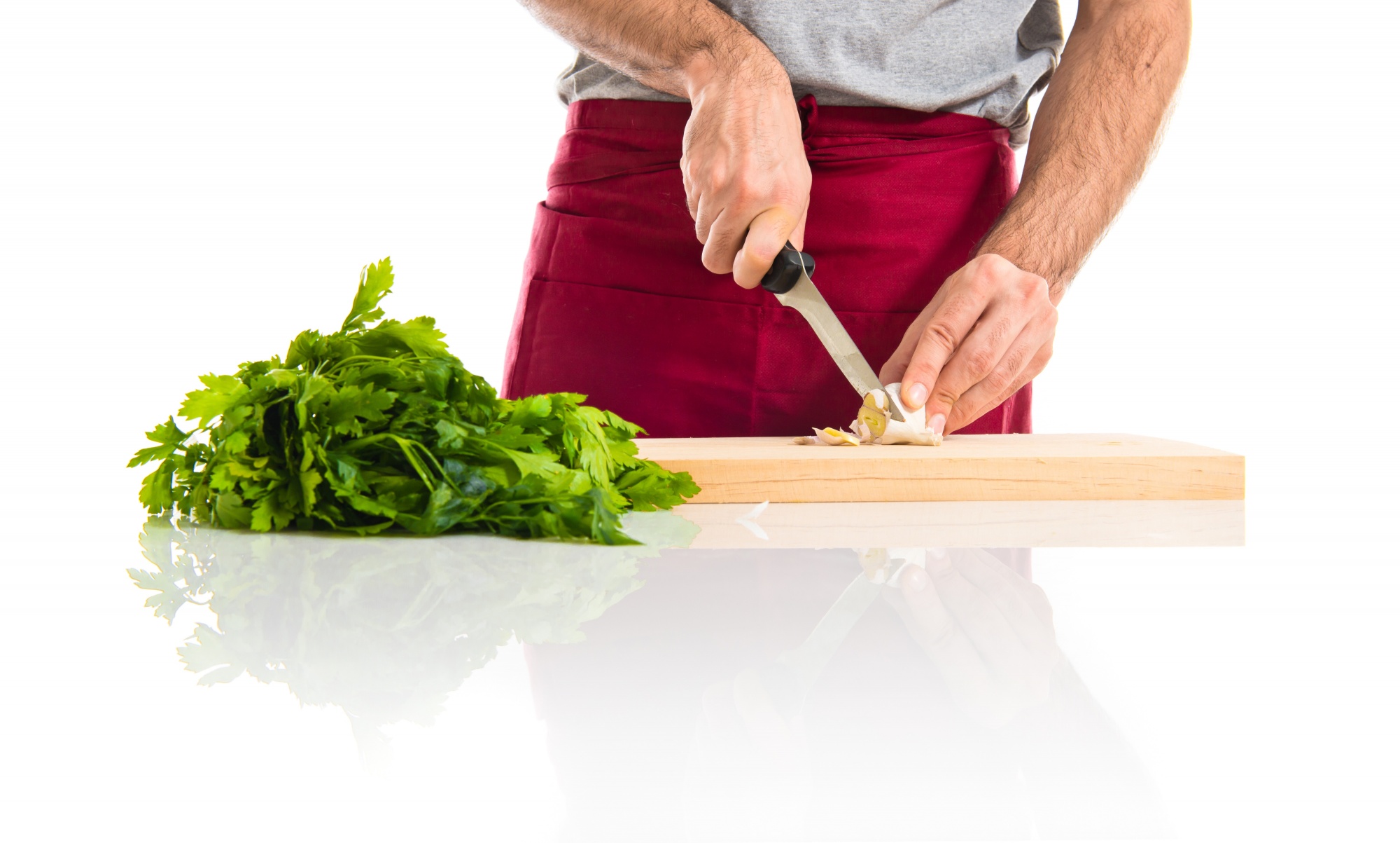 Chef che affetta verdure su tagliere in cucina professionale
